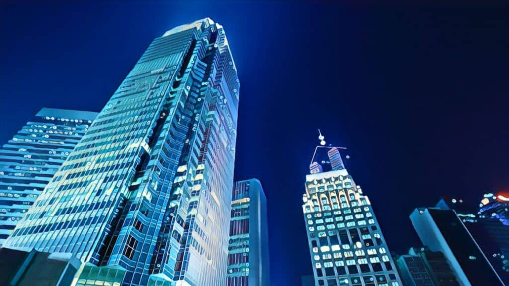 Triple Net Lease (A Need To Know Pros & Cons Guide) tall commercial building blue glass city night lights skyscraper