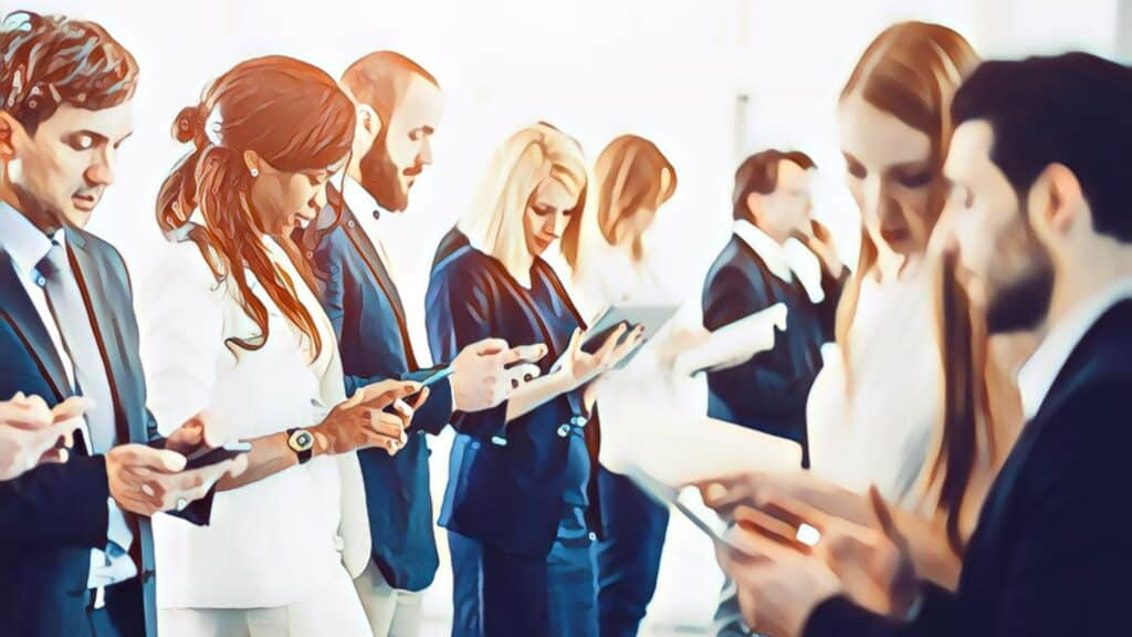 Business people networking, multi-racial, multi-gendered, men, women, business suits, looking down at mobile devices in a group meeting, talking, explaining to each other