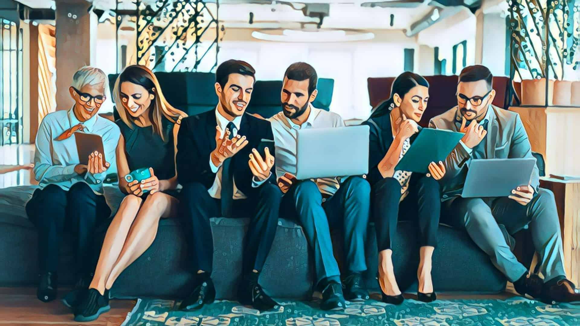 three men and three women sitting interchangeably on a couch looking at papers, folders, and computers, seemingly business networking, sunshine in large skylight background, business attire, business suits, smiling, woman holding coffee mug